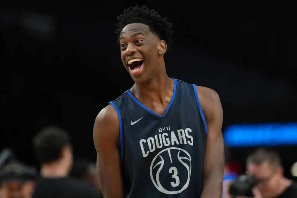 A basketball player in a practice jersey opens his mouth with laughter.