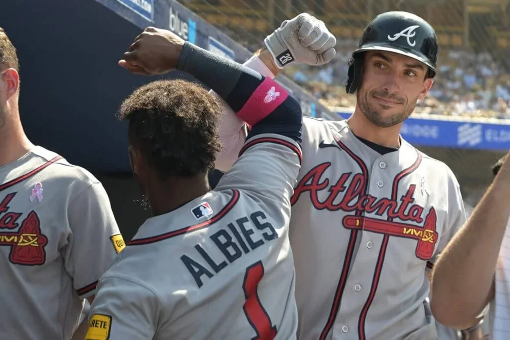 Matt Olson of the Atlanta Braves is congratulated in the dugout by Ozzie Albies after hitting a solo home run during the eithth inning against the Los Angeles Dodgers at Dodger Stadium.