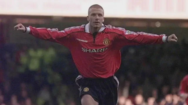 David Beckham, in a red Man Utd shirt, wheels away with his arms outstretched after scoring a free-kick against Leicester City